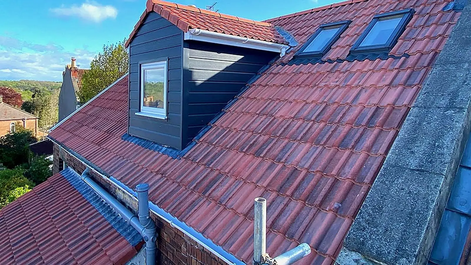 Loft conversion planning permission in Bristol: a grey rear dormer with two roof windows on a red-tiled terrace roof