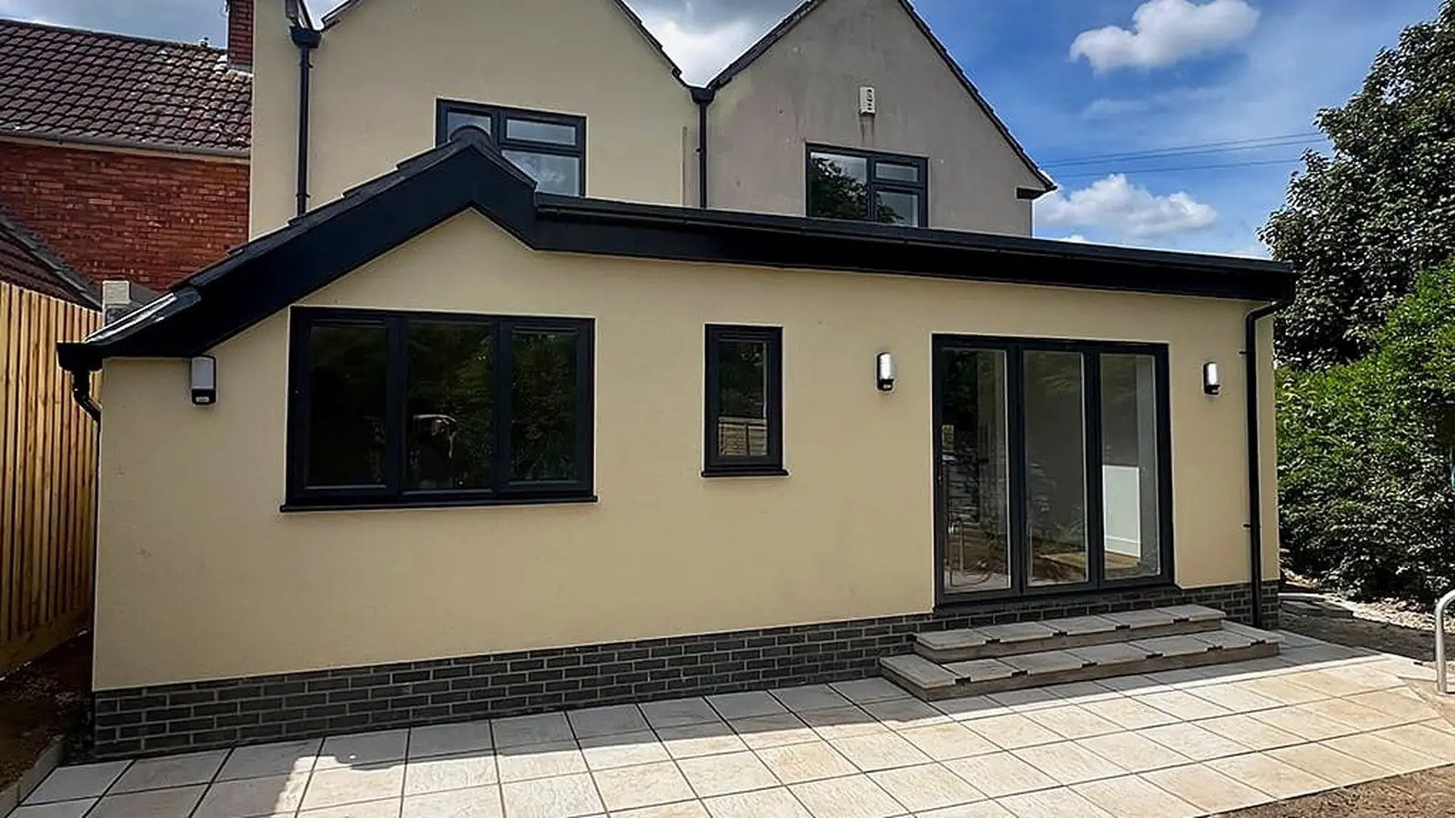 House extension cost guide: a completed cream-render single-storey rear extension and patio built by Wilson & Cole in Bristol