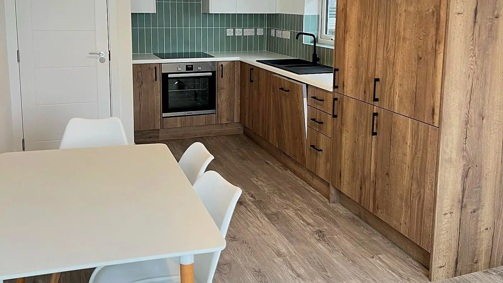 Refurbished buy-to-let kitchen-diner in Bristol with oak-effect units and sage tiles, a Wilson & Cole refurb to let