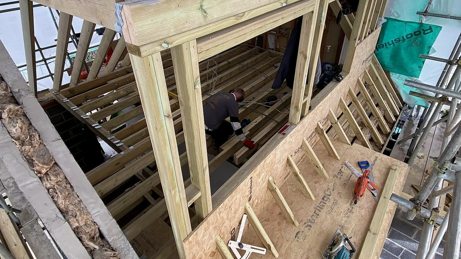 Week two of a Wilson & Cole loft conversion in Bristol: dormer frame and floor joists in under scaffold wrap