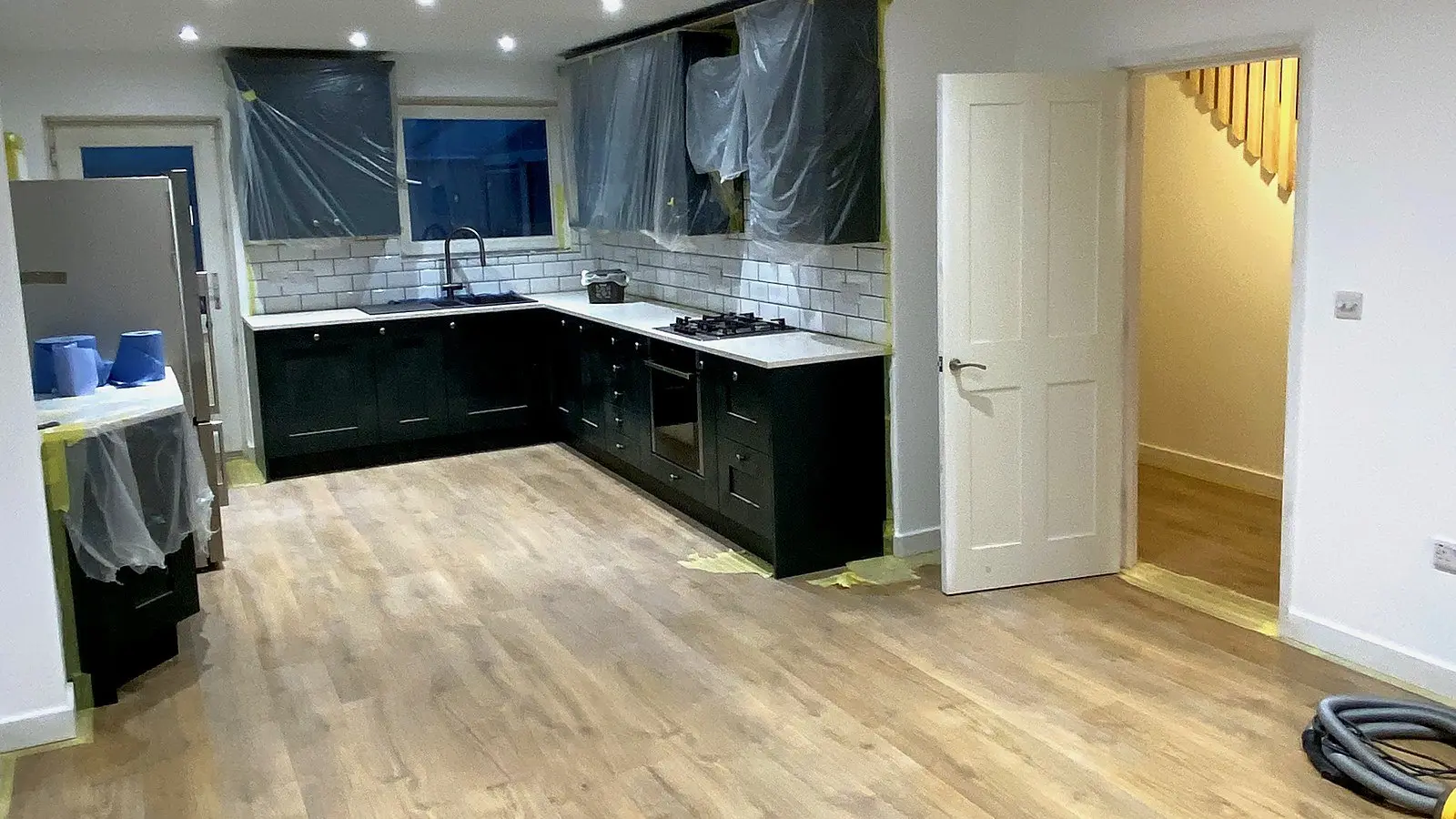 Kitchen under dust sheets on a Wilson & Cole site: how we protect a home for clients living in the house during renovation