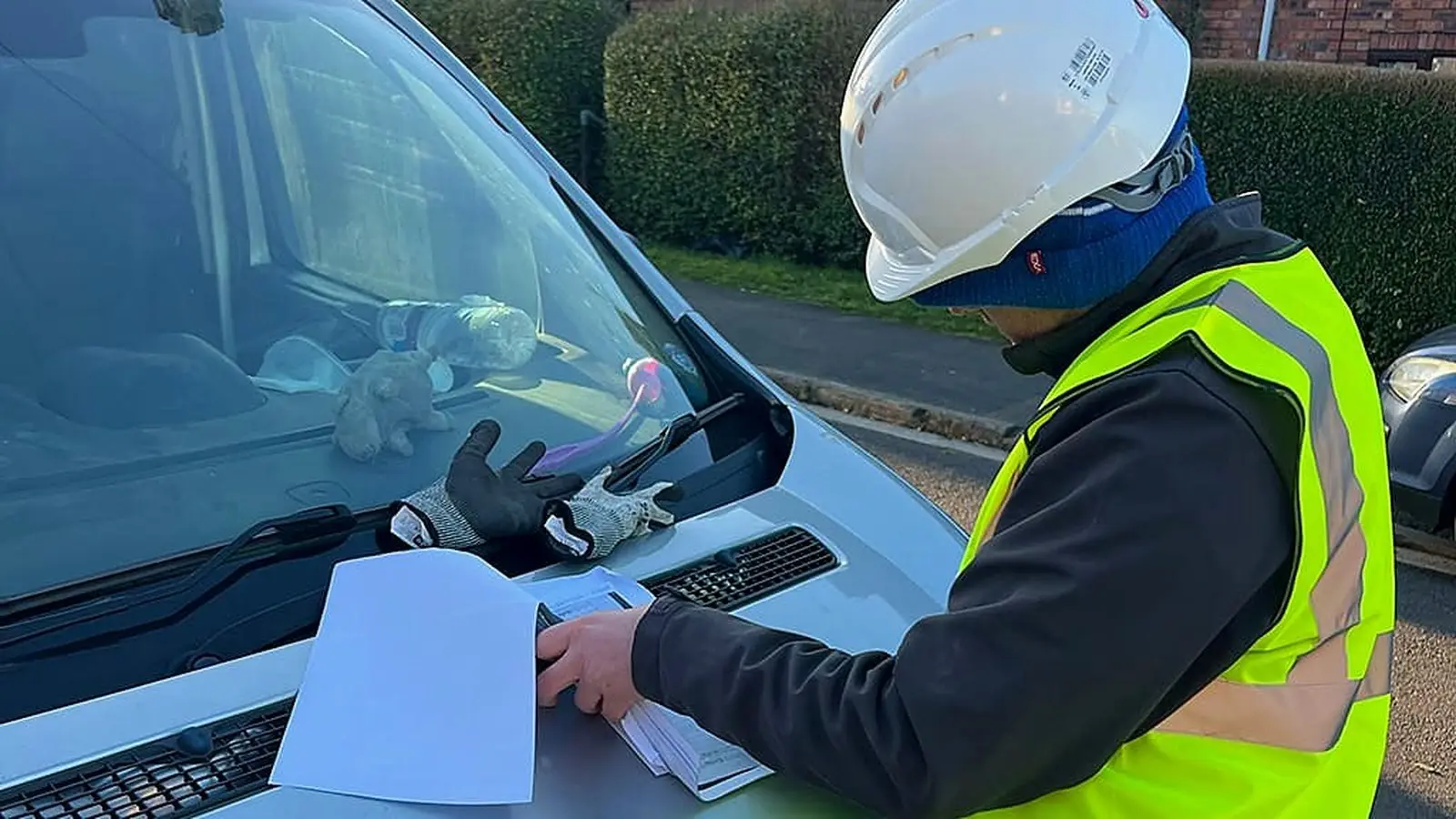Builder reviewing drawings on a van bonnet on a Bristol site, from our guide on how to choose a builder