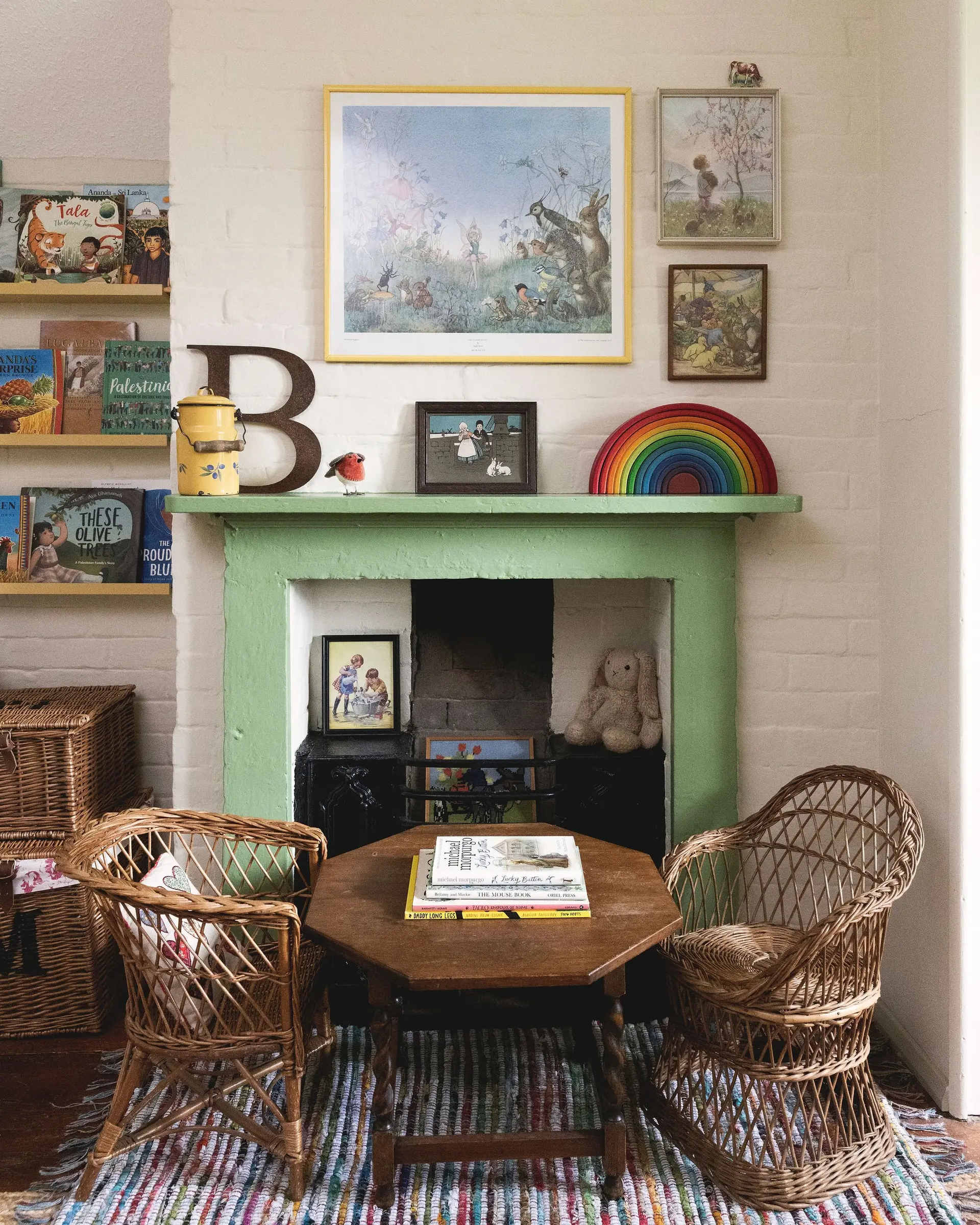 Vintage-inspired children's room with a green fireplace and wicker chairs