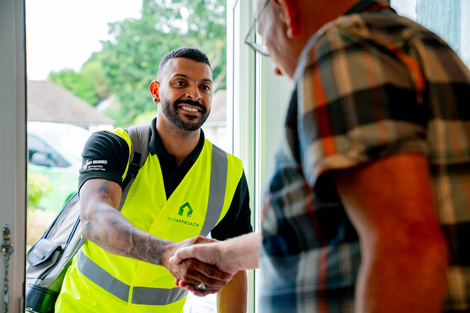 An Eco Approach assessor shaking hands with a homeowner at the door