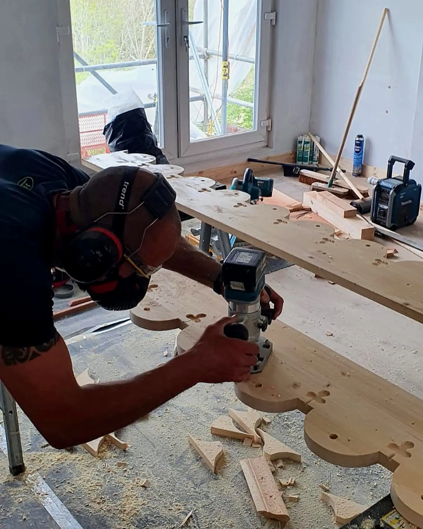 Carpenter hand-finishing decorative roof timber scallops